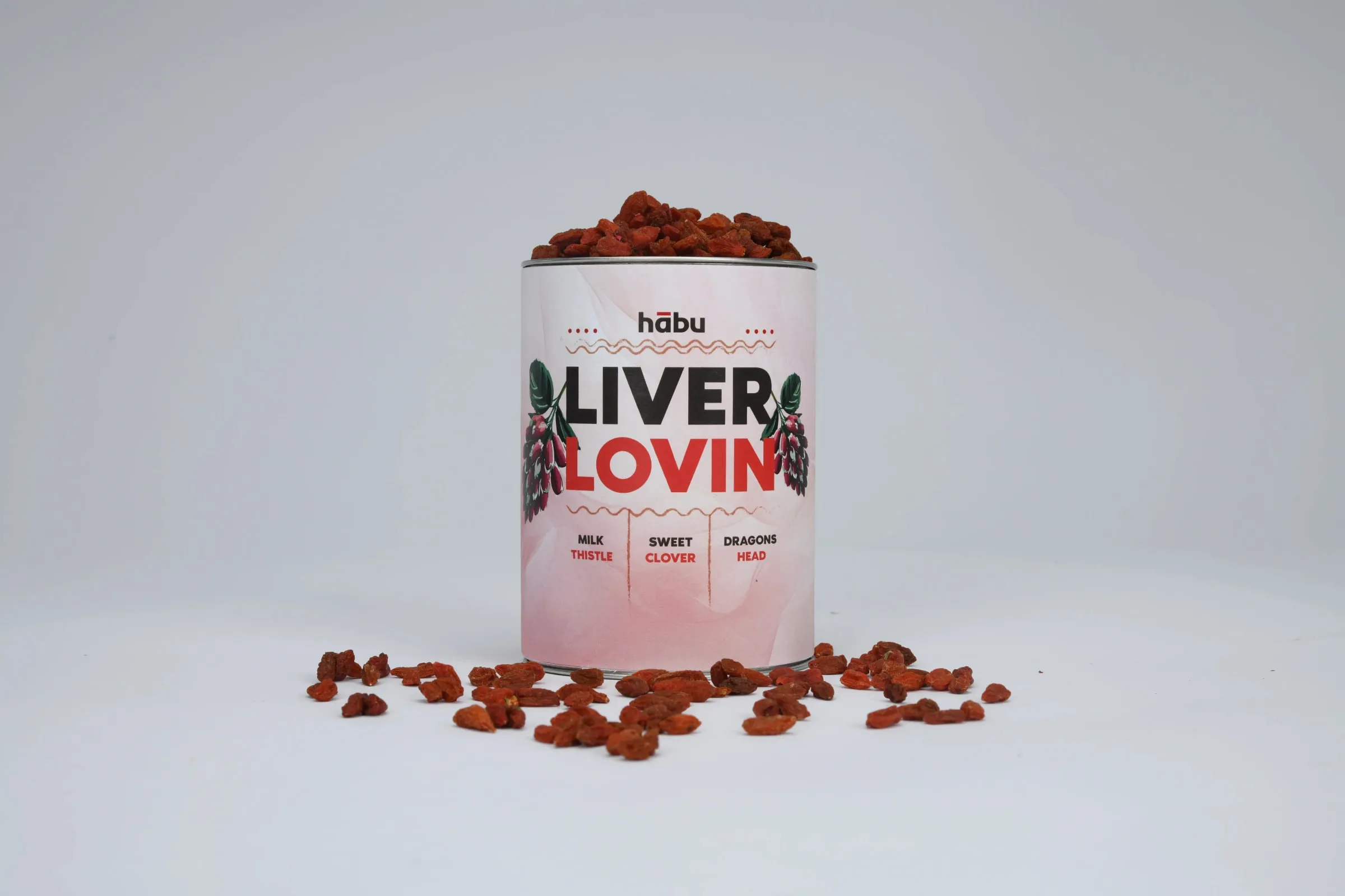 A Liver Lovin' tin topped with dried red berries, more spilling around it.