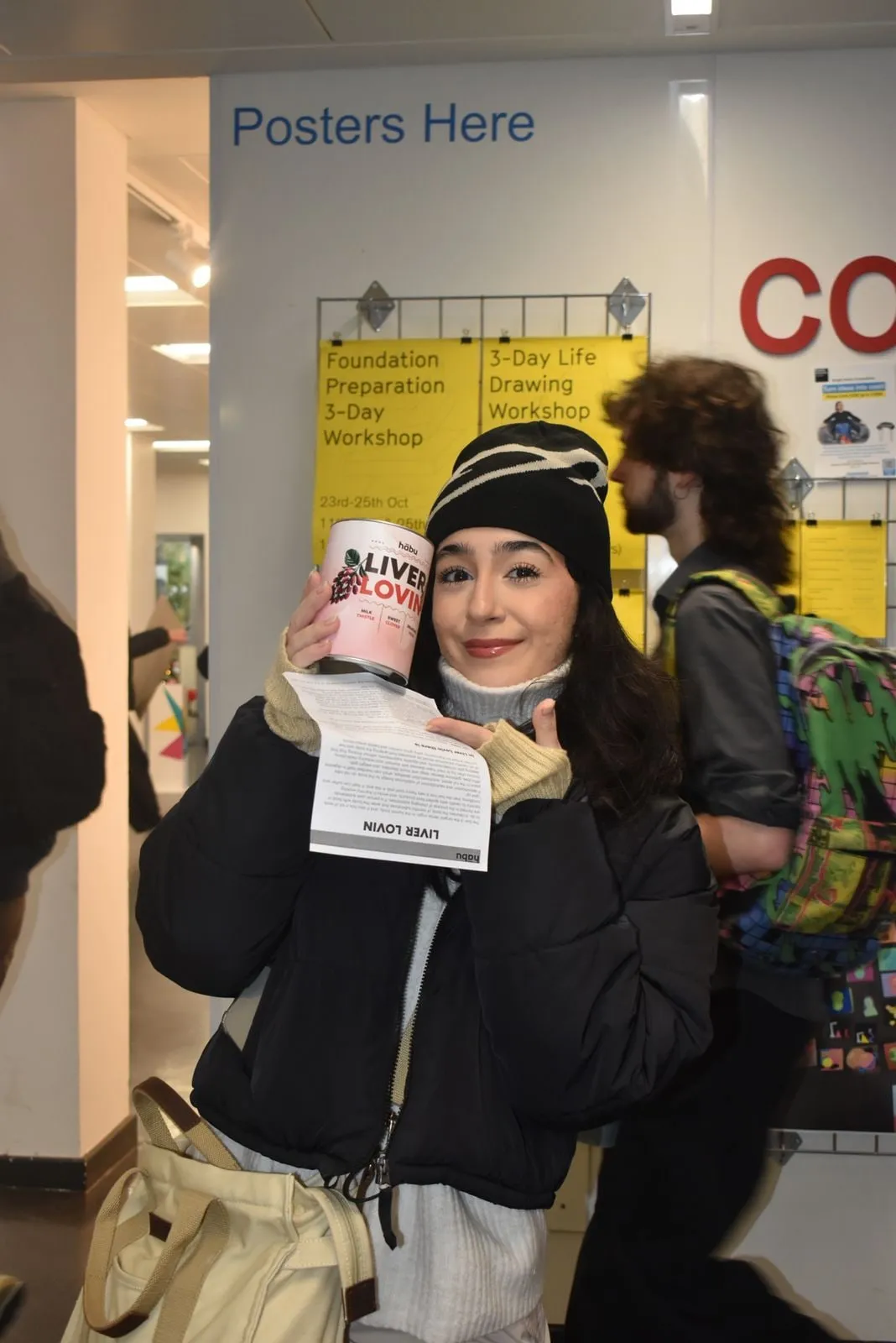 A customer at the launch holding a Habu tin and a leaflet.